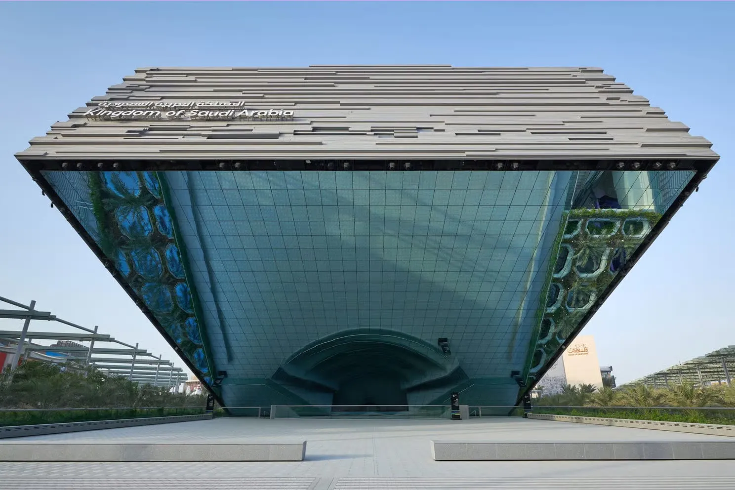 The pavilion's cantilevered volume above the plaza, its underside clad in LED mirror screens
