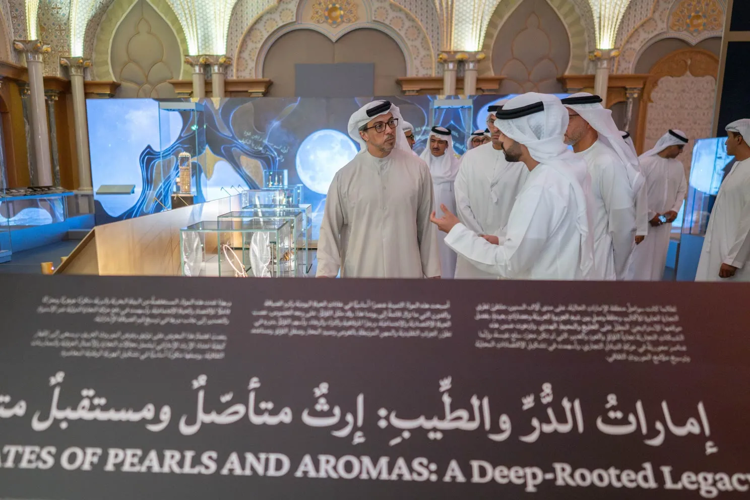 The opening tour at a showcase, beneath the exhibition's bilingual title wall